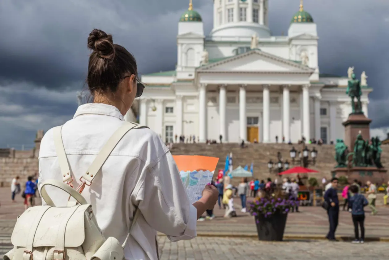Female solo travler in Helsinki looking at map in front of Senate Square Cathredal